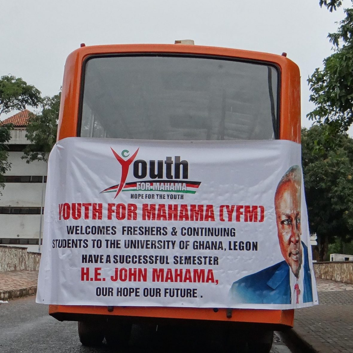white campaign poster on an orange vehicle for a candidate in the Ghanaian presidential election
